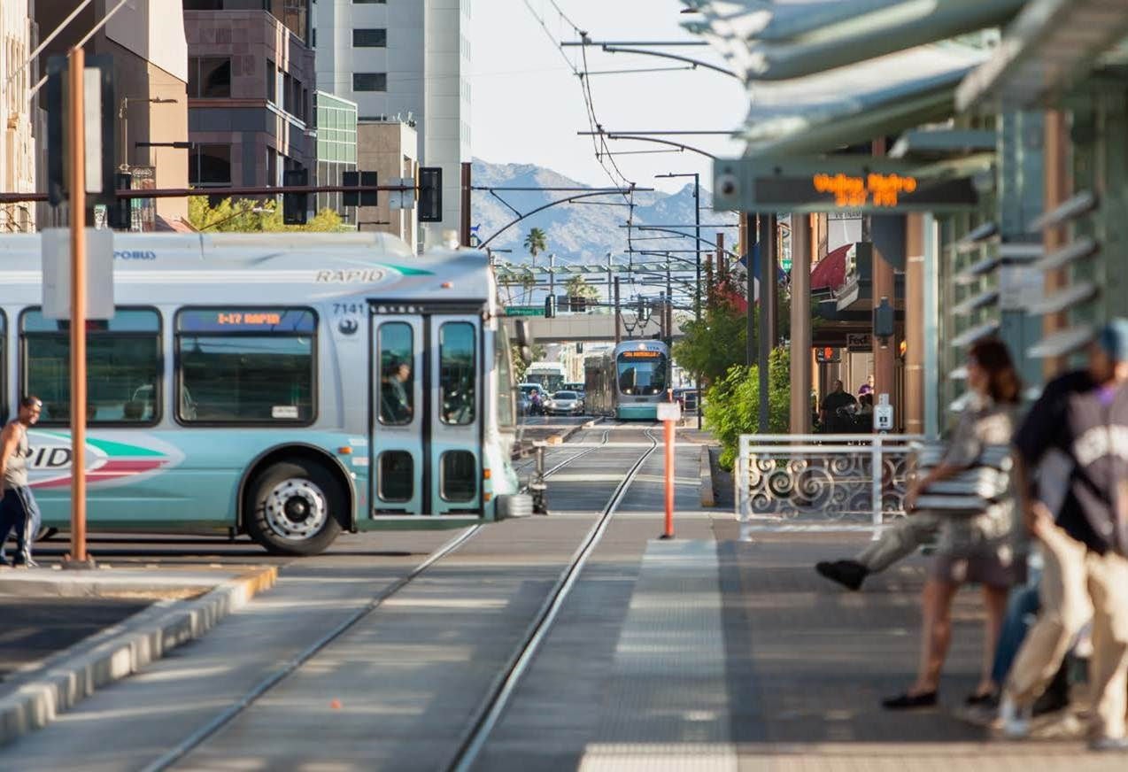 City bus driving over light rail down busy street
